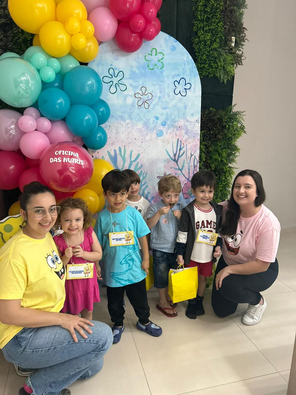 Crianças junto com as nutricionistas no painel do Bob Esponja